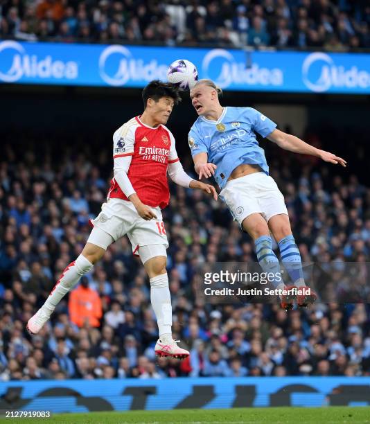 Takehiro Tomiyasu of Arsenal competes for a header with Erling Haaland of Manchester City during the Premier League match between Manchester City and...