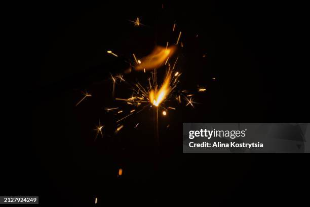 glowing burning bengal fire with beautiful sparks on black background - vonk stockfoto's en -beelden