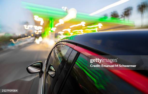driving car is approaching a patrol station while twilight. - vanuit een auto stockfoto's en -beelden