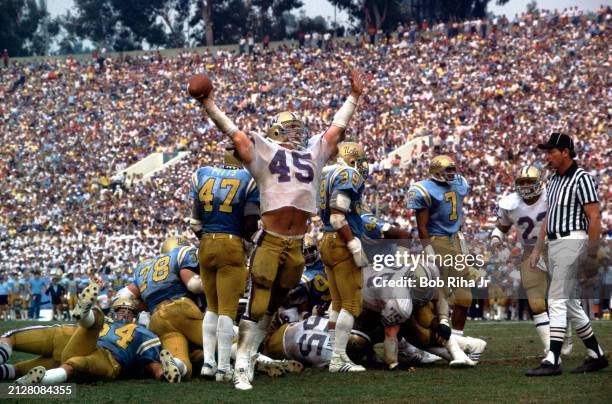 Washington University Fullback Walt Hunt raises his arms in jubilation after scorning a leaping touchdown from 2-yard line for game lead with less...