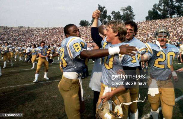 University of California Los Angeles Quarterback Rick Neuheisel celebrates teams win with his teammates following victory over University of...