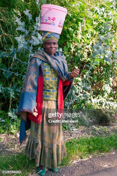 african woman carrying bucket on her head - rwanda stock pictures, royalty-free photos & images
