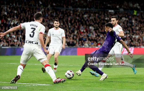 Rodrygo of Real Madrid scores his team's second goal whilst under pressure from Daniel Vivian of Athletic Club during the LaLiga EA Sports match...