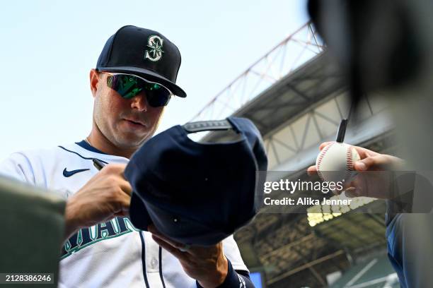 Ty France of the Seattle Mariners signs autographs before the game against the Boston Red Sox at T-Mobile Park on March 31, 2024 in Seattle,...