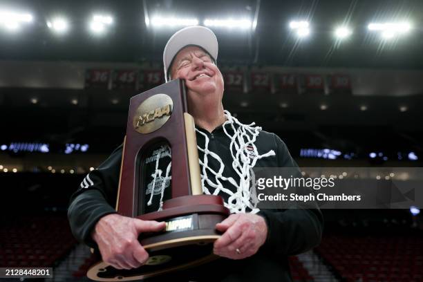 Head coach Wes Moore of the NC State Wolfpack hugs the Portland 4 Regional Championship trophy after defeating the Texas Longhorns 76-66 in the Elite...