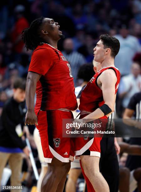 Burns Jr. #30 and Michael O'Connell of the North Carolina State Wolfpack chest bump after a foul in the Elite 8 round of the NCAA Men's Basketball...