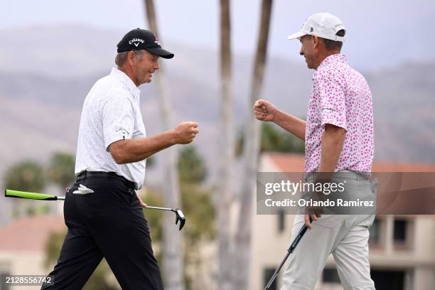 Retief Goosen of South Africa and Steven Alker of New Zealand bump fists after completing the third round of The Galleri Classic at Mission Hills...