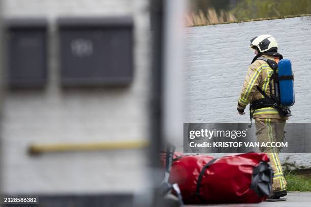 Fireman pictured inside a large security perimeter after three people were found dead in a drug lab in Poederlee near Lille, Antwerp province,...