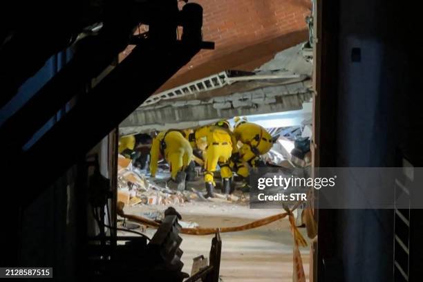 This frame grab from AFPTV video taken on April 3, 2024 shows rescue workers searching for survivors at the damaged Uranus Building in Hualien, after...