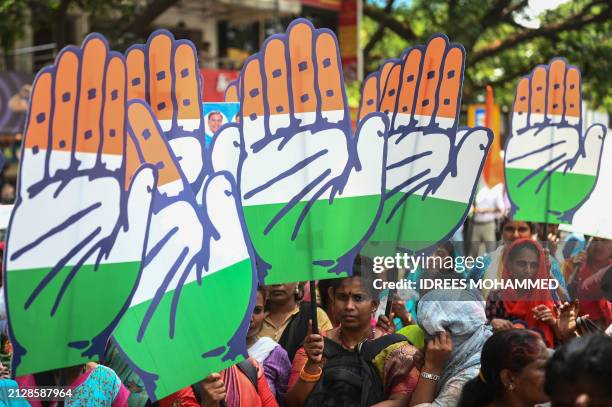 Congress party supporters hold the party's symbol during a roadshow for Mansoor Ali Khan, election candidate for Bengaluru central, in Bengaluru on...