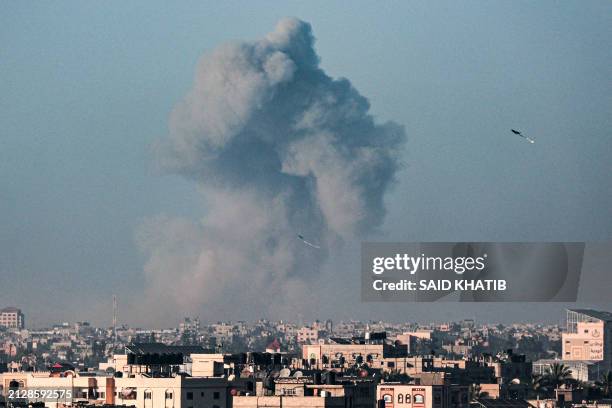 Picture taken from Rafah shows kites flown in the sky above the city as smoke billows during Israeli bombardment on Khan Yunis in the southern Gaza...