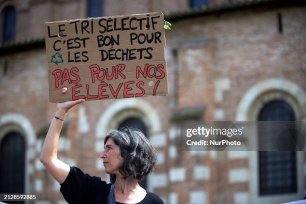 Woman is holding a cardboard sign that reads 'Selecting, it's for garbage, not for our pupils' in Toulouse, France, on April 2, 2024. All unions have...