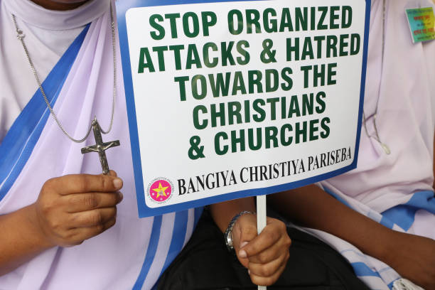 Nun is holding a placard while members of Bangiya Christiya Pariseba are participating in a protest against the alleged attacks on churches, priests,...