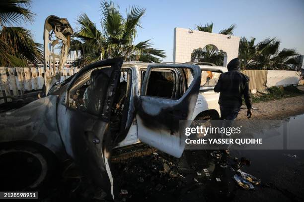Palestinian inspects near a vehicle where employees from the World Central Kitchen , including foreigners, were killed in an Israeli airstrike,...