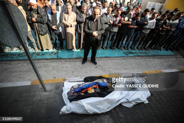 Mourners offer funeral prayers next to the body of Palestinian Issam Abu Taha, a worker from the World Central Kitchen , who was killed in an Israeli...