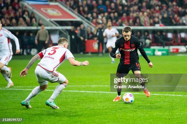 Florian Wirtz of Leverkusen scores his team's third goal agains Andre Hoffmann of Duesseldorf during the DFB cup semifinal match between Bayer 04...