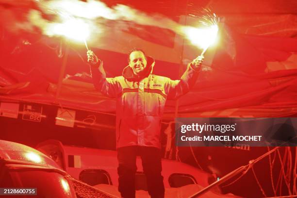 Frenchman Francis Joyon, skipper of the maxi-trimaran "IDEC II", celebrates his victory with distress flares, 20 January 2008 in Brest, after...