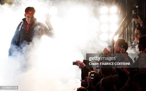 Switzerland's Roger Federer waves to spectators as he arrives to play against Spain's Rafael Nadal during a charity tennis game on December 21, 2010...