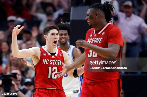 Michael O'Connell of the North Carolina State Wolfpack and DJ Burns Jr. #30 of the North Carolina State Wolfpack react after drawing a foul in the...