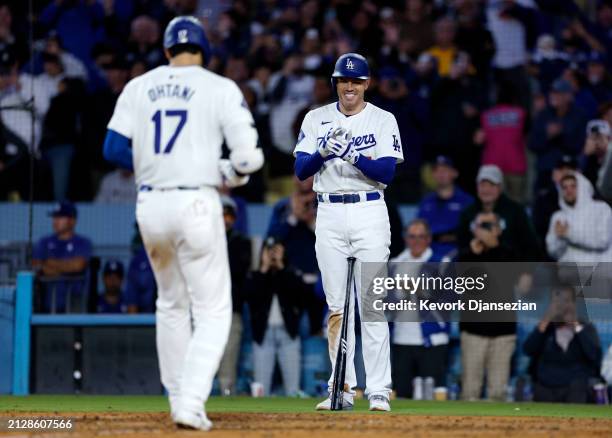 Shohei Ohtani of the Los Angeles Dodgers is congratulated by Freddie Freeman after hitting a solo home run during the seventh inning against the San...