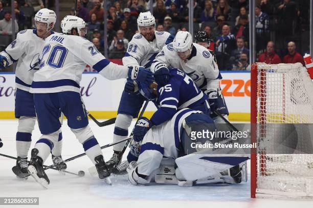 Toronto Maple Leafs right wing Ryan Reaves is mobbed by Tampa Bay Lightning left wing Nicholas Paul , Tampa Bay Lightning defenseman Erik Cernak and...