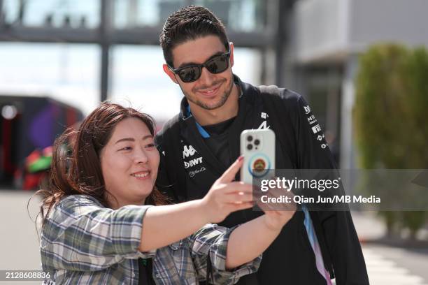 Esteban Ocon of France and BWT Alpine F1 Team with a fan during previews ahead of the F1 Grand Prix of Japan at Suzuka International Racing Course on...