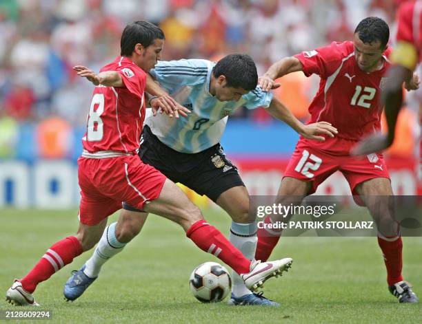 Tunisian midfielders Slim Benachour and Jawhar Mnari vies with Argentina's midfielder Juan Roman Riquelme during the Confederations cup football...