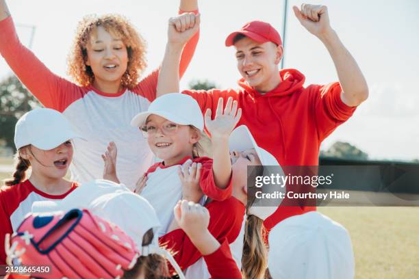 little league squad and coaches unite in celebration of winning home run - baseball team celebration stock pictures, royalty-free photos & images