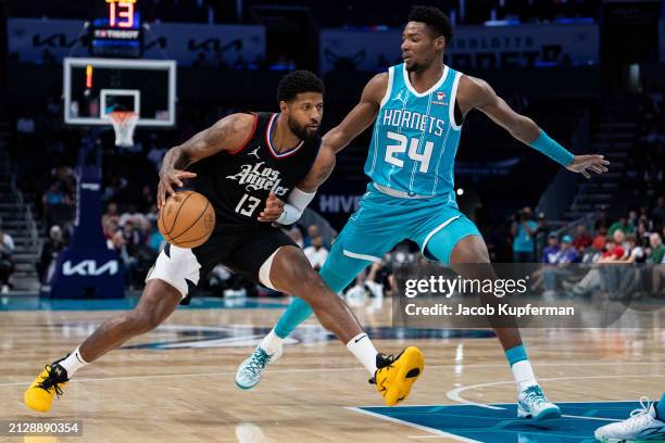 Brandon Miller of the Charlotte Hornets guards Paul George of the LA Clippers during their game at Spectrum Center on March 31, 2024 in Charlotte,...