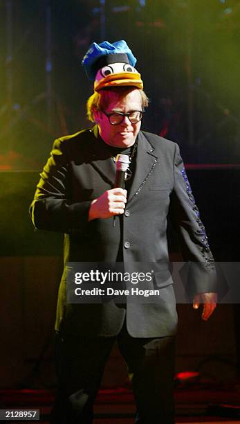 British singer songwriter Sir Elton John, wearing a Donald Duck hat, performs on stage at the Old Vic Theatre in London on February 5, 2003. The...