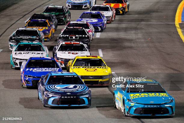 Denny Hamlin, driver of the Mavis Tires & Brakes Toyota, leads Martin Truex Jr., driver of the Auto-Owners Insurance Toyota, on the restart to win...