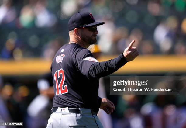 Manager Stephen Vogt of the Cleveland Guardians signals the bullpen to make a pitching change against the Oakland Athletics in the bottom of the...