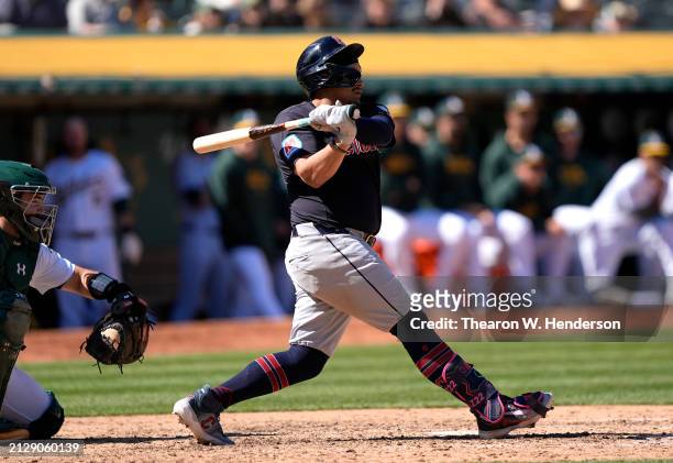 Josh Naylor of the Cleveland Guardians hits an rbi single scoring Jose Ramirez against the Oakland Athletics in the top of the eighth inning on March...