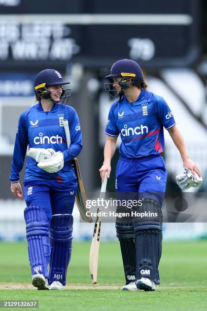 Charlie Dean and Amy Jones of England leave the field after after winning game one of the Women's ODI series between New Zealand and England at Basin...