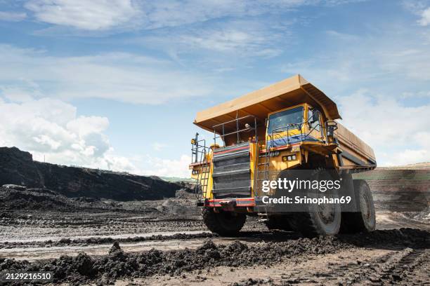 coal loading truck at mining site: vital machinery for energy production and industrial operations - camión-de-descarga fotografías e imágenes de stock