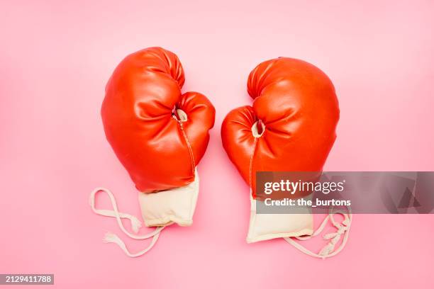pair of red boxing gloves on pink background - guante de boxeo fotografías e imágenes de stock