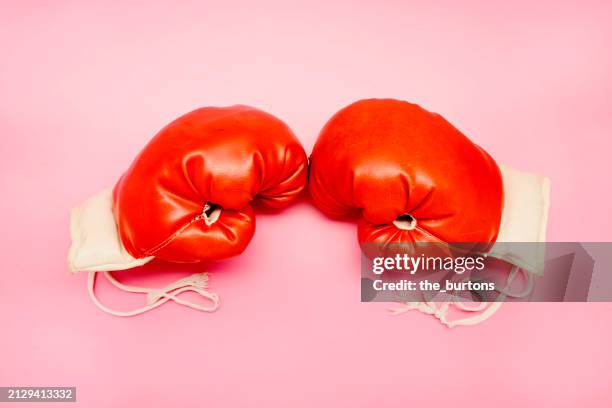 pair of red boxing gloves on pink background - boxing glove coloured background stock pictures, royalty-free photos & images