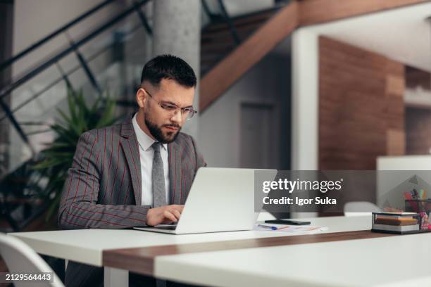 hombre de negocios trabajando en la computadora portátil en la oficina - un solo hombre fotografías e imágenes de stock