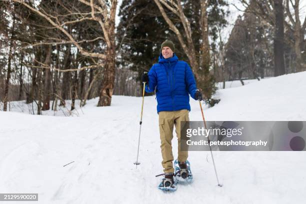 a man snowshoeing in a snowy forest - iwate prefecture stock pictures, royalty-free photos & images