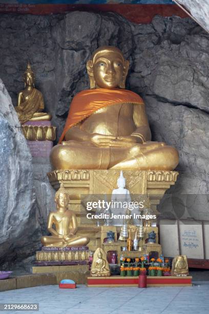 buddist statue at pak ou cave's on mekong river, luang prabang, laos. - jenner stock pictures, royalty-free photos & images