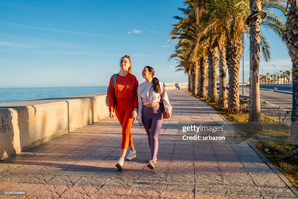 Two Female Friends Walking Home After Running Outdoors In Málaga In Spain