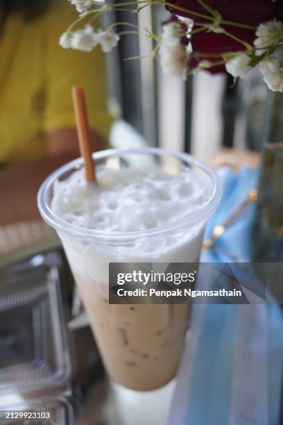 close up view of ice cubes in cold brewed coffee cappuccino in plastic cup put on wooden desk blurred background, drink beverage - sugary coffee drink stock pictures, royalty-free photos & images