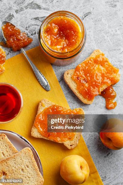 marmellata di albicocche su pane tostato. pane tostato con marmellata di albicocche. marmellata di albicocche. gelatina di albicocche su pane tostato. - marmellata di agrumi foto e immagini stock