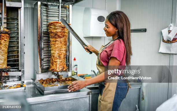 arbeiterin bereitet gyros in einem fast-food-restaurant zu - gyros stock-fotos und bilder