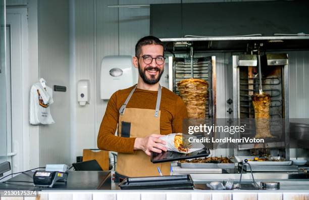 männlicher arbeiter in einem fast-food-laden - kebab stock-fotos und bilder