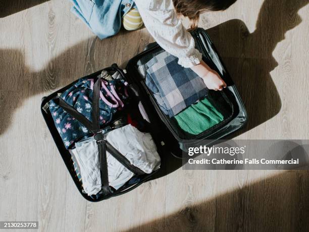 top down of a child packing a small suitcase - fiesta nacional fotografías e imágenes de stock