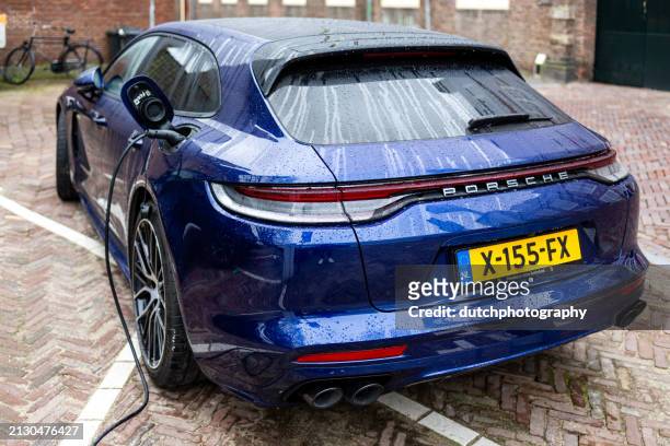back view of blue porsche panamera 4s e-hybrid parked and changing  in the street - redactioneel 個照片及圖片檔