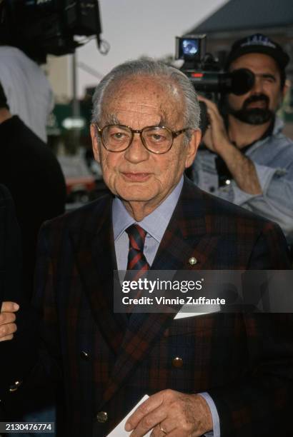 Italian film producer Dino De Laurentiis, wearing a plaid blazer over a blue shirt with a diagonally-striped blue-and-red tie, attends the Westwood...