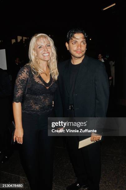 American actor and dancer Michael DeLorenzo, wearing a black suit over a black crew-neck top, and his guest, who wears a black lace top, attend the...