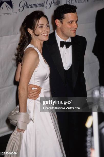 American actress Kim Delaney, wearing a white evening gown, and American fashion designer Isaac Mizrahi, who wears a tuxedo and bow tie, attend the...